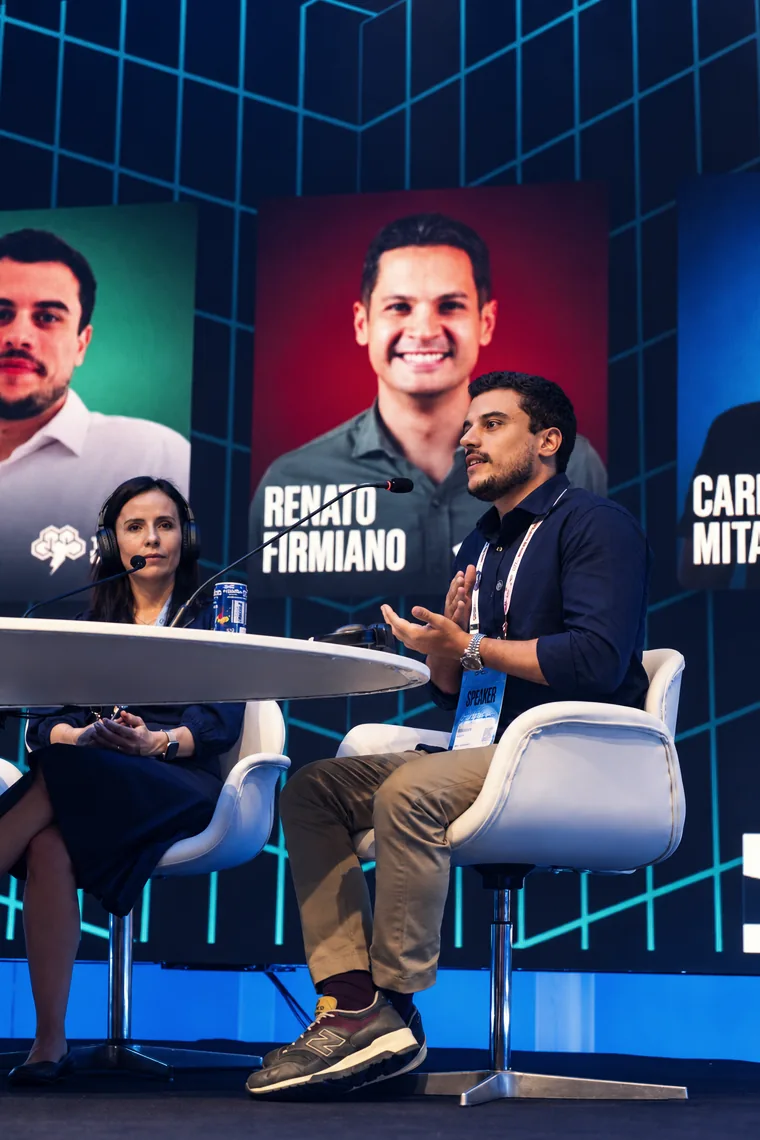 Mesa de debate en el escenario, con cuatro personas sentadas