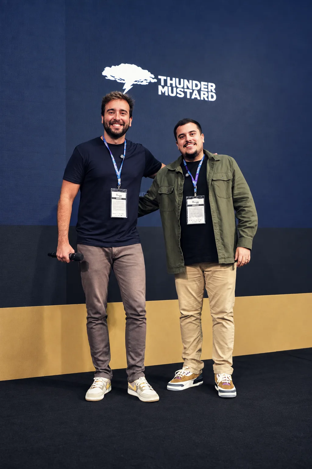 Los dos socios de Thunder en el escenario, frente al panel de la marca
