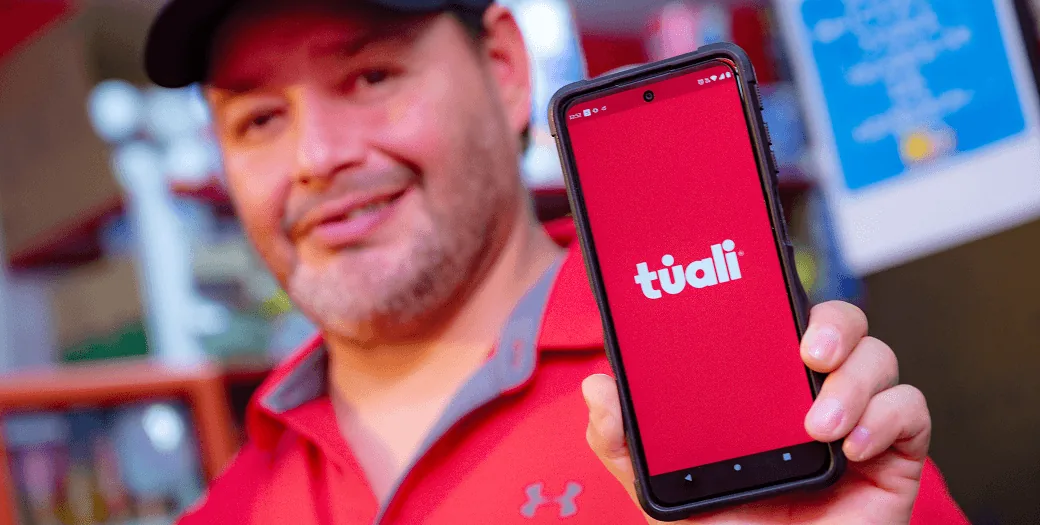 Varejista apresentando o aplicativo de compras túali no celular