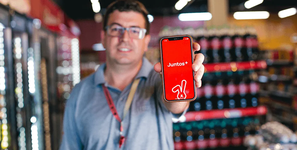 Varejista exibindo a marca Juntos+ na tela do celular